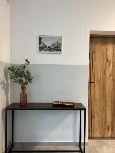 a table with a vase on it in a room at Niron Apartamenty Królowej Jadwigi Złotów in Złotów