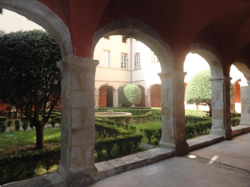 een uitzicht op een tuin door een boog bij Chez Mi, centre ville, parking gratuit, arrivée autonome in Saint-Chinian