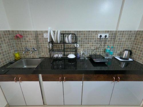 a kitchen with a sink and a counter top at Horizon Apartment 1BHK in Pune