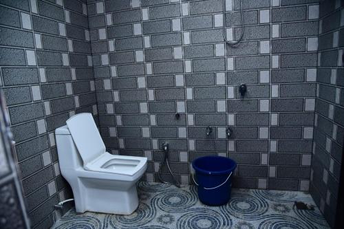 a bathroom with a toilet and a brick wall at MOUNTAIN VIEW HOLIDAY HOME ( A M HOMESTAY) in Kalpetta
