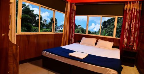 a bed in a room with a window at MOUNTAIN VIEW HOLIDAY HOME ( A M HOMESTAY) in Kalpetta