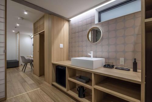 a bathroom with a sink and a mirror at Spatium Ginza Pony in Tokyo