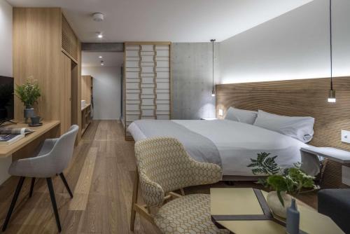 a hotel room with a bed and a desk and chairs at Spatium Ginza Pony in Tokyo