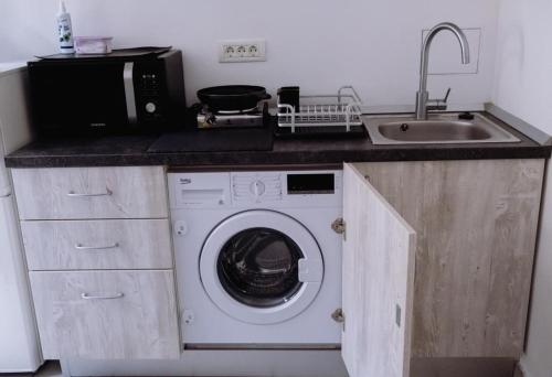 una cucina con lavatrice e microonde di ☆ Bulevard Apartments ☆ a Arad