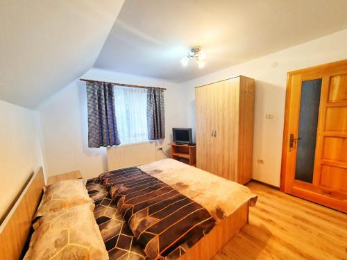 a bedroom with a large bed in a room at Cabana Denisa in Râu de Mori