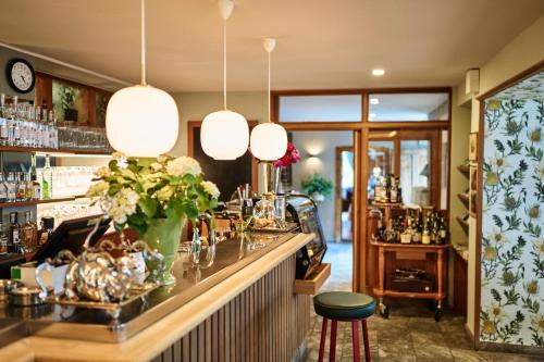 a bar with a vase of flowers at Goldene Rose Karthaus a member of Small Luxury Hotels of the World in Senales
