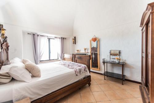 a bedroom with a bed and a mirror and a window at Casa del Nebbiolo in Camino