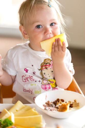 a little girl sitting at a table eating food at Thermenhotel Kurz in Lutzmannsburg