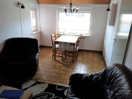 ein Wohnzimmer mit einem Tisch, Stühlen und einem Sofa in der Unterkunft Ferienwohnung Noeska 85020 in Ostrhauderfehn