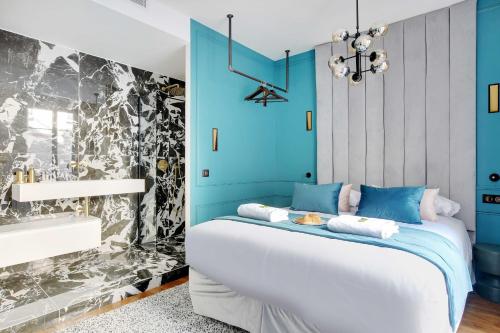 ein blaues Schlafzimmer mit einem weißen Bett und einer schwarz-weißen Tapete in der Unterkunft Amazing Appart 2BR/6P - Bastille/ Gare de Lyon 4 in Paris