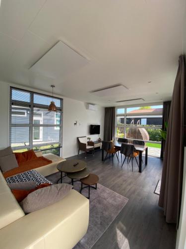 a living room with a couch and a table at LUXUS Cube Ferienhaus Chalet am See mit Schwimmbad in Lathum NL in Lathum