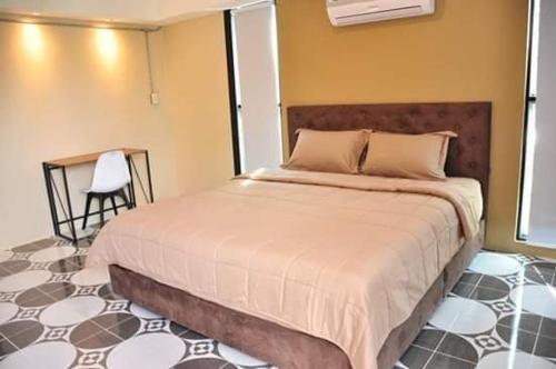 1 dormitorio con 1 cama, 1 mesa y 1 silla en Vwara Resort en Buriram