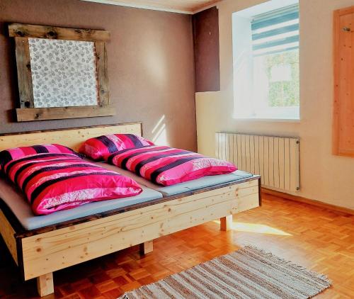 a bed with red pillows on it in a room at Appartement Jakalar in Vils