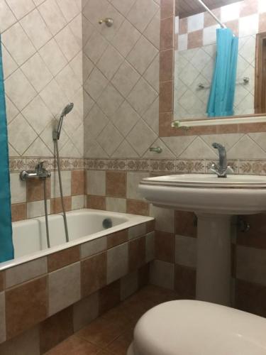 a bathroom with a sink and a toilet and a tub at Valentina Apartments in Gouves