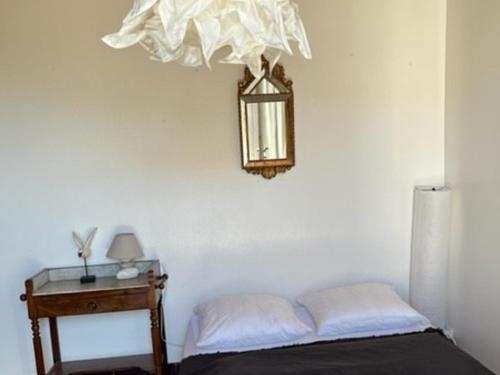 ein Schlafzimmer mit einem Bett und einem Kronleuchter an der Wand in der Unterkunft Maison La Flotte, 5 pièces, 6 personnes - FR-1-544-3 in La Flotte