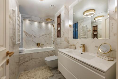 y baño con lavabo, aseo y bañera. en Jonas Mekas Alley Apartments - Jono Meko Skersvėjis, en Vilna