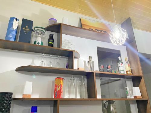 a shelf with bottles and glasses on it at Tranquil One Bedroom - Karen in Nairobi