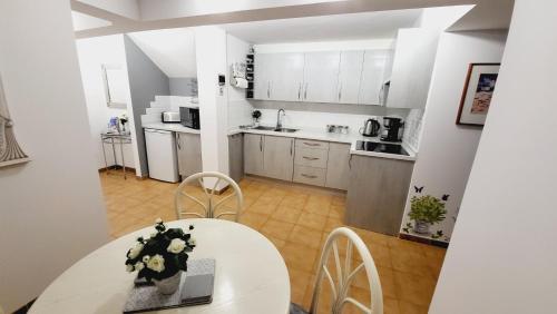 a small kitchen with a white table and chairs at Casa Tranquila in Playa de San Juan