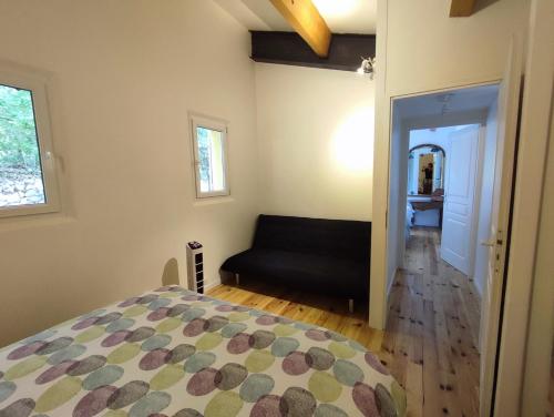 a bedroom with a bed and a couch in a room at Maison Couquets Bauduen in Bauduen