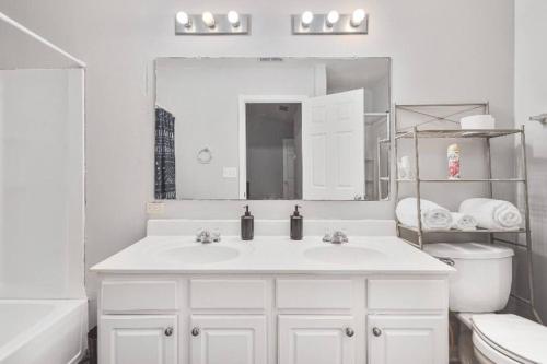 La salle de bains blanche est pourvue d'un lavabo et d'un miroir. dans l'établissement Beautiful Cozy 3-Bedroom Townhome Retreat, à Atlanta