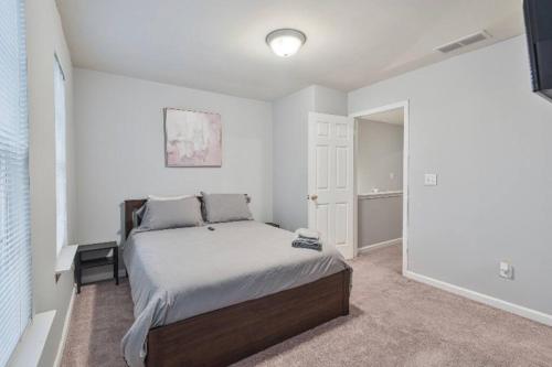 a bedroom with a bed in a white room at Beautiful Cozy 3-Bedroom Townhome Retreat in Atlanta