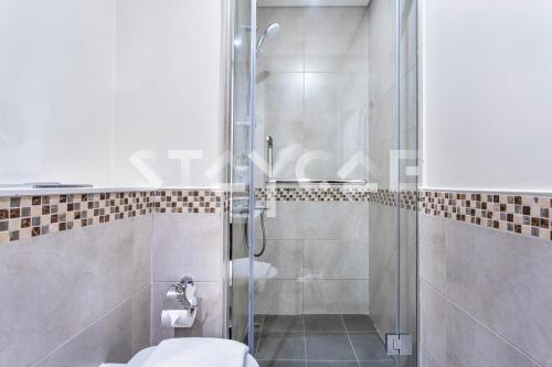 uma casa de banho com uma cabina de duche em vidro e um WC. em Staycae Holiday Homes - Reva no Dubai