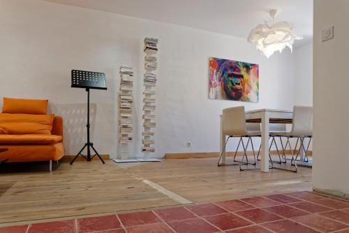 ein Wohnzimmer mit einem Tisch, Stühlen und einem Gemälde in der Unterkunft Du bonheur et du bon air à Banyuls ! in Banyuls-sur-Mer