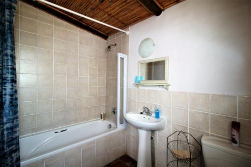 a bathroom with a sink and a tub and a toilet at Baywatch Paternoster - The Cottage in Paternoster