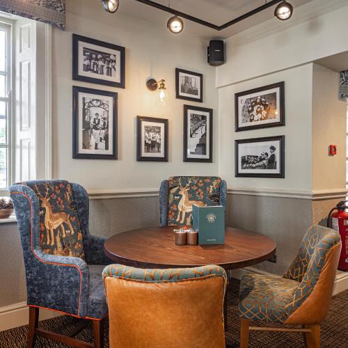 a waiting room with chairs and a table with a laptop at The Crown Hotel, Boroughbridge, North Yorkshire - The Coaching Inn Group in Boroughbridge