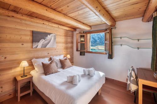 ein Schlafzimmer mit einem Bett in einem Holzzimmer in der Unterkunft Chalet Charline in Tignes