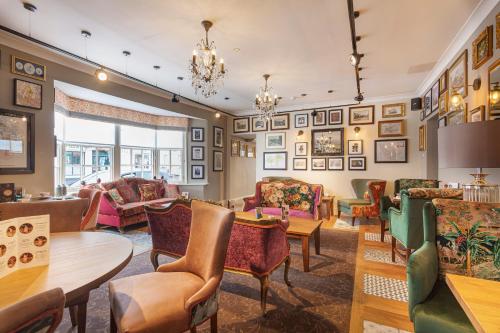a living room with chairs and tables at The Crown Hotel, Boroughbridge, North Yorkshire - The Coaching Inn Group in Boroughbridge