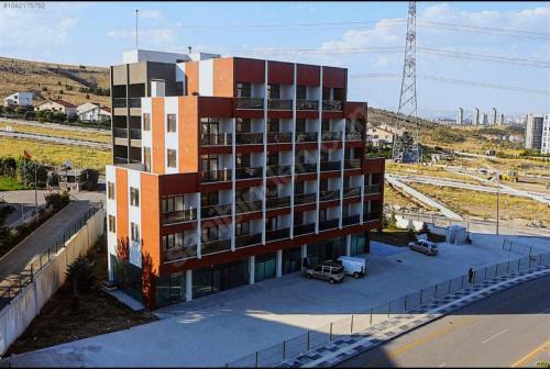 a tall building with a parking lot in front of it at COLORFUL LİFE ÇAYYOLU in Ankara