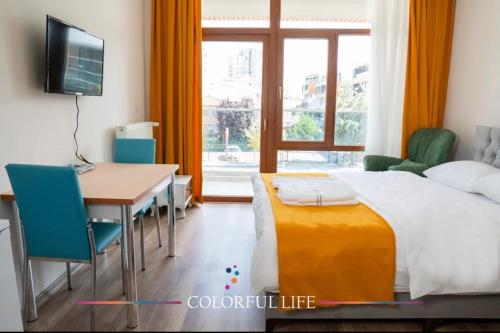 Cette chambre comprend un lit, un bureau et une table. dans l'établissement COLORFUL LİFE ÇAYYOLU, à Ankara