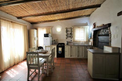 a kitchen with a table and chairs and a kitchen with at Baywatch Paternoster - The Cottage in Paternoster