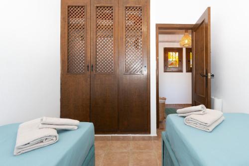 Habitación con 2 camas y puerta con toallas en 228 Lovely Home La Zenia - Alicante Holiday en Playa Flamenca