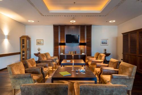 - un salon avec des chaises, une table et une télévision dans l'établissement Precise Resort Bad Saarow - Golf & Spa, à Bad Saarow