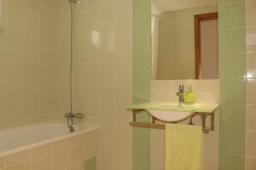 een badkamer met een wastafel en een bad bij Apartamento Formosa Mar by YHA in Cabanas de Tavira