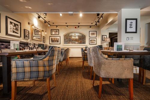 a restaurant with a bar with tables and chairs at The Crown Hotel, Boroughbridge, North Yorkshire - The Coaching Inn Group in Boroughbridge