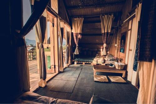 a bedroom in a house with a bed and windows at Tiệm Cà Phê Mer Homestay & Coffee Mộc Châu in Mộc Châu