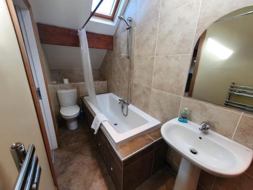La salle de bains est pourvue d'un lavabo, d'une baignoire et de toilettes. dans l'établissement St Ives, à Halifax