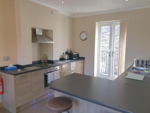 a kitchen with a black counter top and a window at St Ives in Halifax