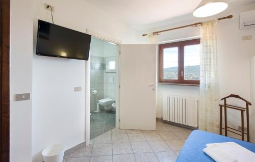 Schlafzimmer mit einem TV an der Wand und einem Badezimmer in der Unterkunft B&B Le Vedute in Rende