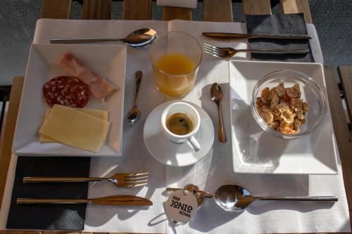 a table with a plate of food and a cup of coffee at B&B JONIO Roma in Rome