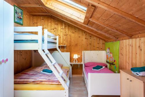 two bunk beds in a room with wooden walls at Stifterhof App Mathilda in Rio Bianco