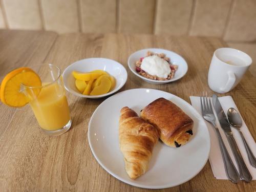 a table with a plate of breakfast food and a glass of orange juice at George Hotel in London