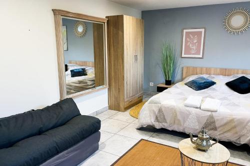 une chambre avec un lit, un canapé et un miroir dans l'établissement #DZ Le LouHaiZi T2, à Seyssinet-Pariset