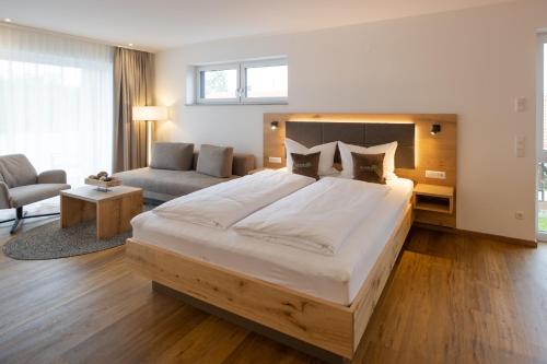 Hotel Restaurant Zur Linde في Erbach: غرفة نوم كبيرة مع سرير كبير وأريكة