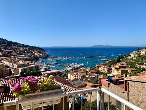 Cette chambre offre une vue sur une ville fleurie depuis son balcon. dans l'établissement Terrazza 81, à Porto Santo Stefano