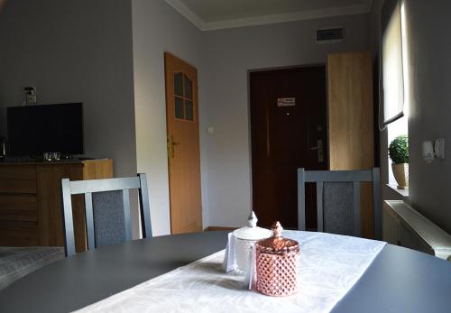 a table with two chairs and a candle on it at Apartament Adabet in Kępno