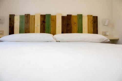 a bed with two pillows in a room with wooden walls at B&B JONIO Roma in Rome